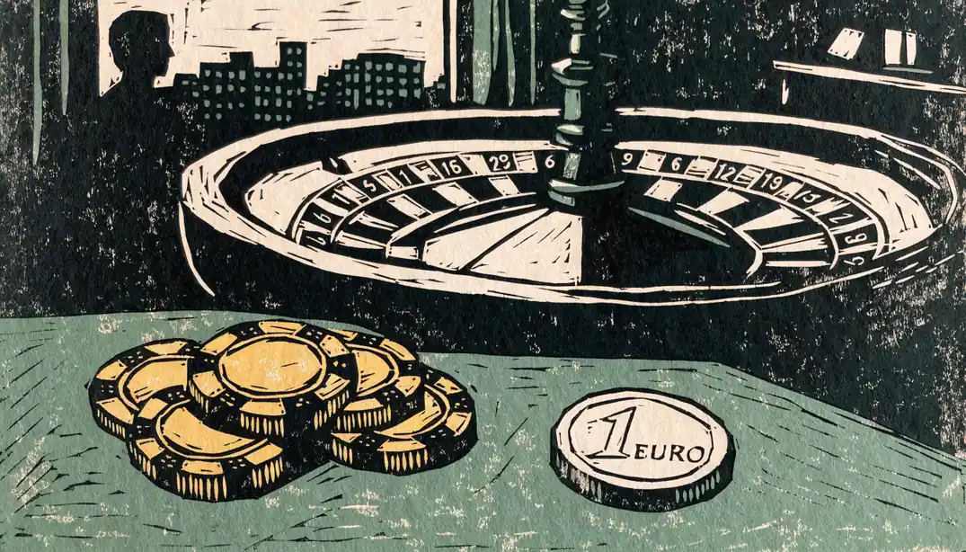 Ein Stapel Spielchips und eine 1-Euro-Münze auf einem grünen Filztisch vor einem Roulettekessel.